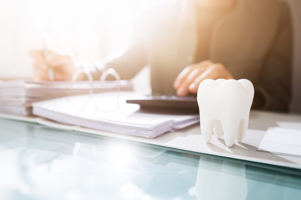 Dentist going over financial documents with tooth graphic in the foreground