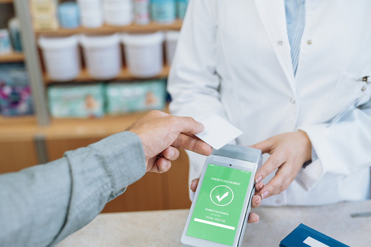 Pharmacist working in pharmacy and serving customer, checking supplies using technologies