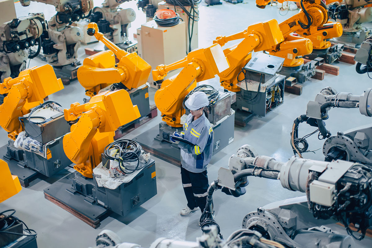 Engineer staff worker working in large machine assembly plant. employee work icounting inspection inventory of machine robot arm