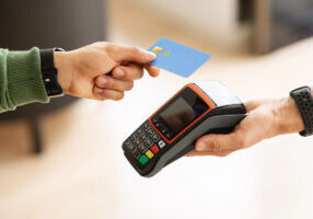 Crop of man customer paying for goods and services with credit card at cafe or store.