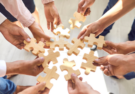 Team members holding puzzle pieces